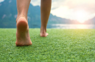person's feet walking on the grass