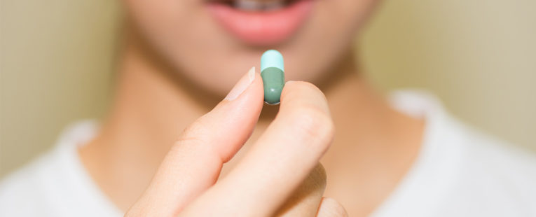 Close-up of woman taking antibiotics