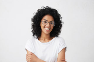 Young African-American woman in glasses smiling.