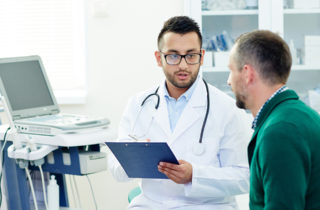middle-aged man talks to doctor about prostate exams