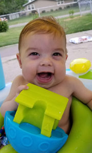Baby smiling in a pool 