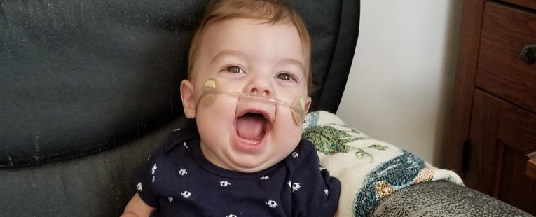 Baby smiling in a chair.
