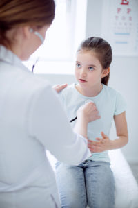 doctor performs school physicals