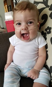 baby smiling in a chair