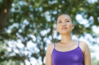 young woman cancer survivor standing in a park