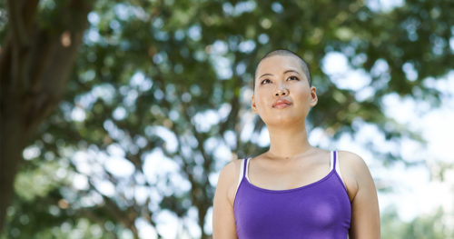 young woman cancer survivor standing in a park