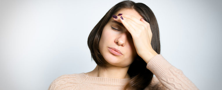 Woman with hand on forehead suffering from a headache