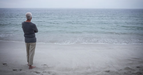 man contemplating at the beach