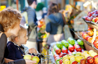 Mother and son shopping for produce at a grocery store