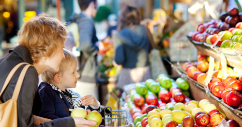Mother and son shopping for produce at a grocery store