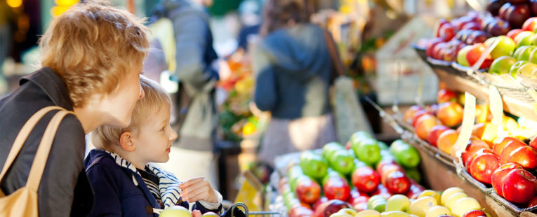 Mother and son shopping for produce at a grocery store