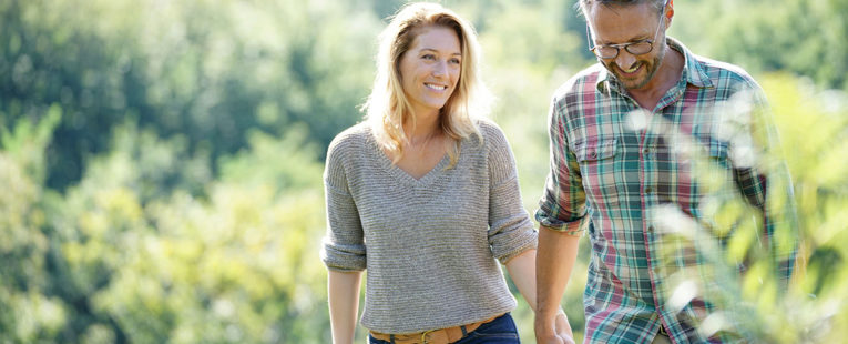 Man and Woman Walking in Field