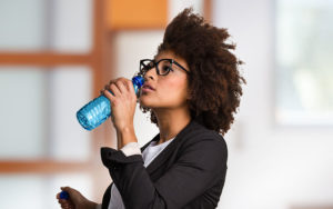 African-American businesswoman drinking bottled water