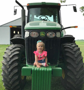 Adalie Guth sitting on a tractor