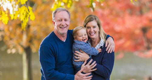 Rick and Angela Farnan along with their son, Blaze standing outside in autumn.