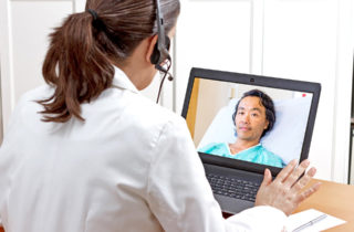 Tele-neurohospitalist meeting with a patient over the computer.