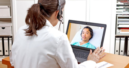 Tele-neurohospitalist meeting with a patient over the computer.