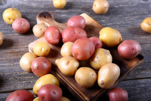 Red and Yukon Gold potatoes on a rustic cutting board. 