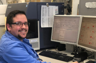 Joshua Barrett, Clinical Laboratory Scientist. He is working in our Flow Cytometry department, analyzing sample results and graphs.