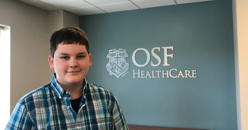 Kaleb stands by OSF HealthCare Children's Hospital sign