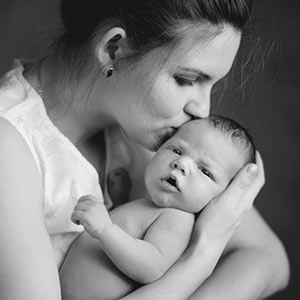 Mother kissing newborn