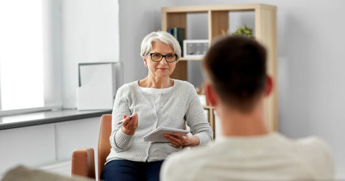 young man with anxiety speaking with therapist