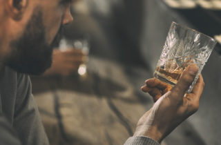 heart conscious alchohol drinker stares at glass of whiskey