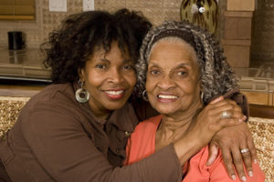 senior mother and adult daughter hugging