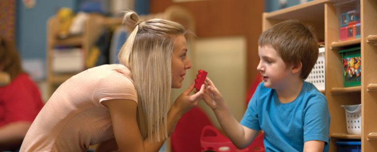 Therapist playing with young boy with autism