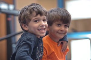 Two young brothers smiling at Autism Collective