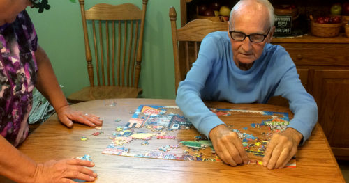 Harry and Terry Alexander putting a jigsaw puzzle together in their dining room