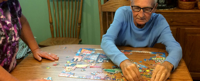 Harry and Terry Alexander putting a jigsaw puzzle together in their dining room