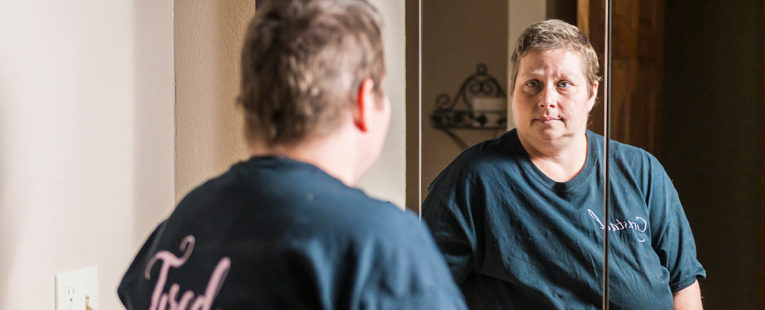 Crystal Dolbee looking at herself in the mirror