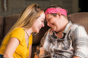 Crystal Dolbee and teenage daughter cuddling at home.