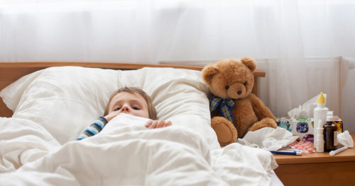 Male toddler with fever in bed