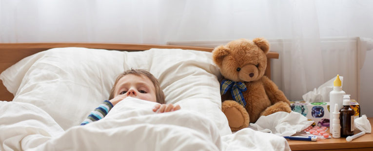 Male toddler with fever in bed