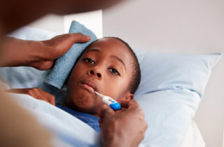 Father comforting his young son with fever