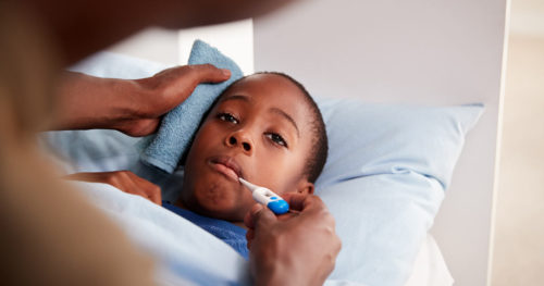 Father comforting his young son with fever