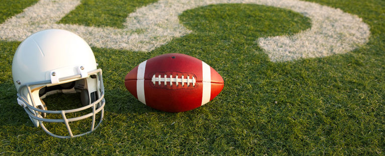 Football and helmet on field