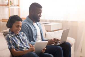 Father on son playing on tablets