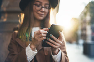 woman walking and texting on smartphone