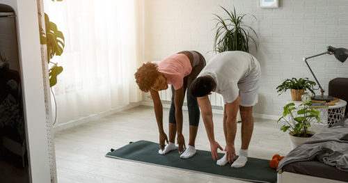Couple exercising in their apartment.