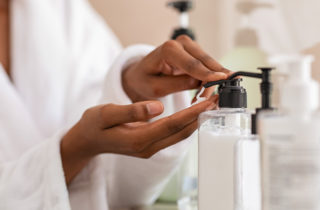 Woman applying moisturizing lotion on her dry hands.