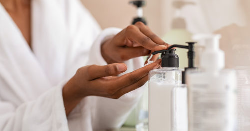 Woman applying moisturizing lotion on her dry hands.