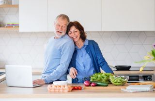 Senior couple cooking healthy food in kitchen.