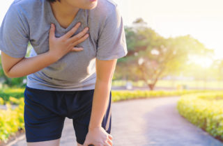 Woman runner suffering asthma attack on trail.