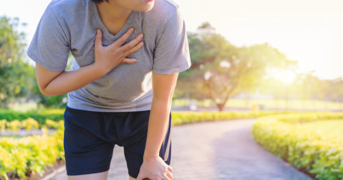 Woman runner suffering asthma attack on trail.