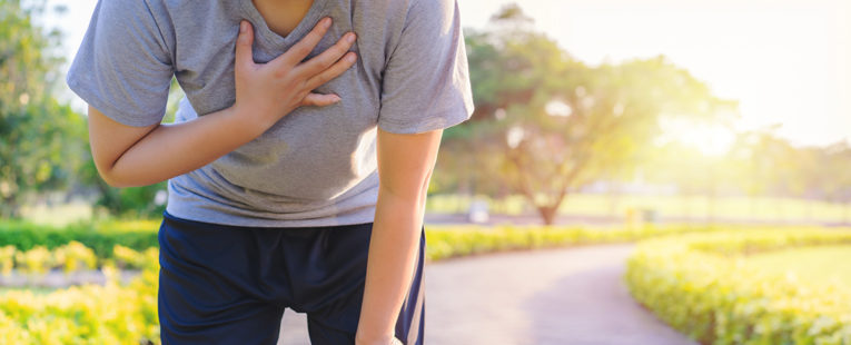 Woman runner suffering asthma attack on trail.