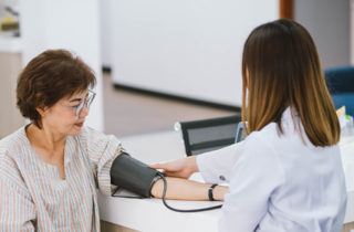 Female with hypertension getting blood pressure checked by health care provider.