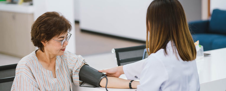 Female with hypertension getting blood pressure checked by health care provider.